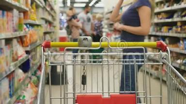<strong>超市</strong>里的一个女人正从柜台边经过篮子。 一个女人在<strong>超市</strong>里走来走去，特写镜头。